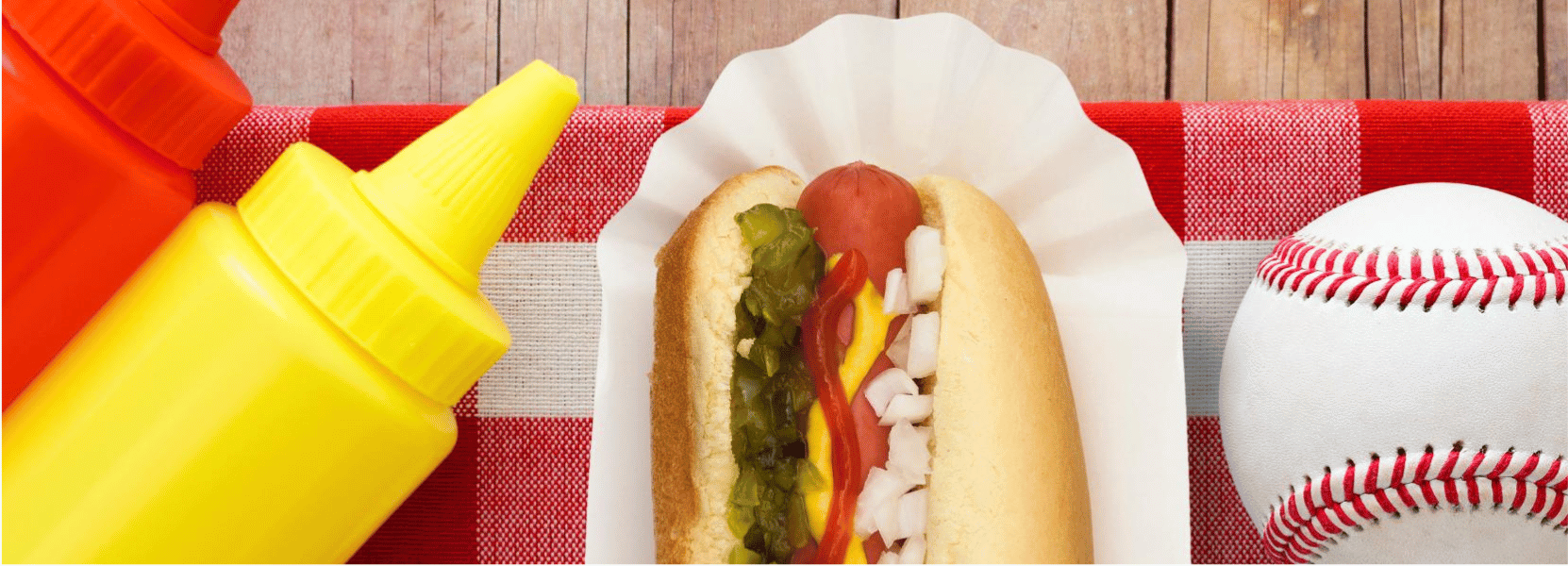 Hotdog with mustard next to a basceball