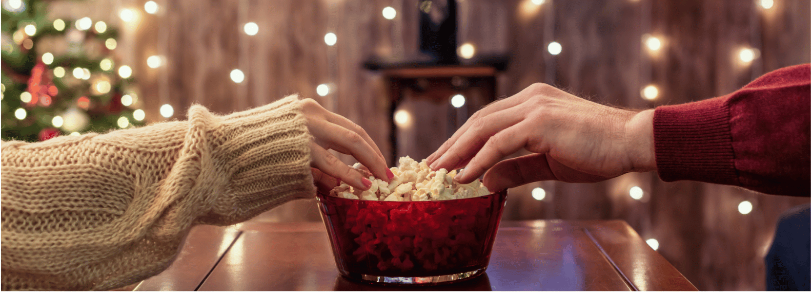 two hands share bowl of popcorn guide to movie lover gifts